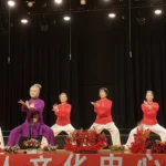 Senior Tai Chi practitioners in red and purple uniforms performing Chen-style Tai Chi on stage at Hawthorn Arts Centre, Melbourne
